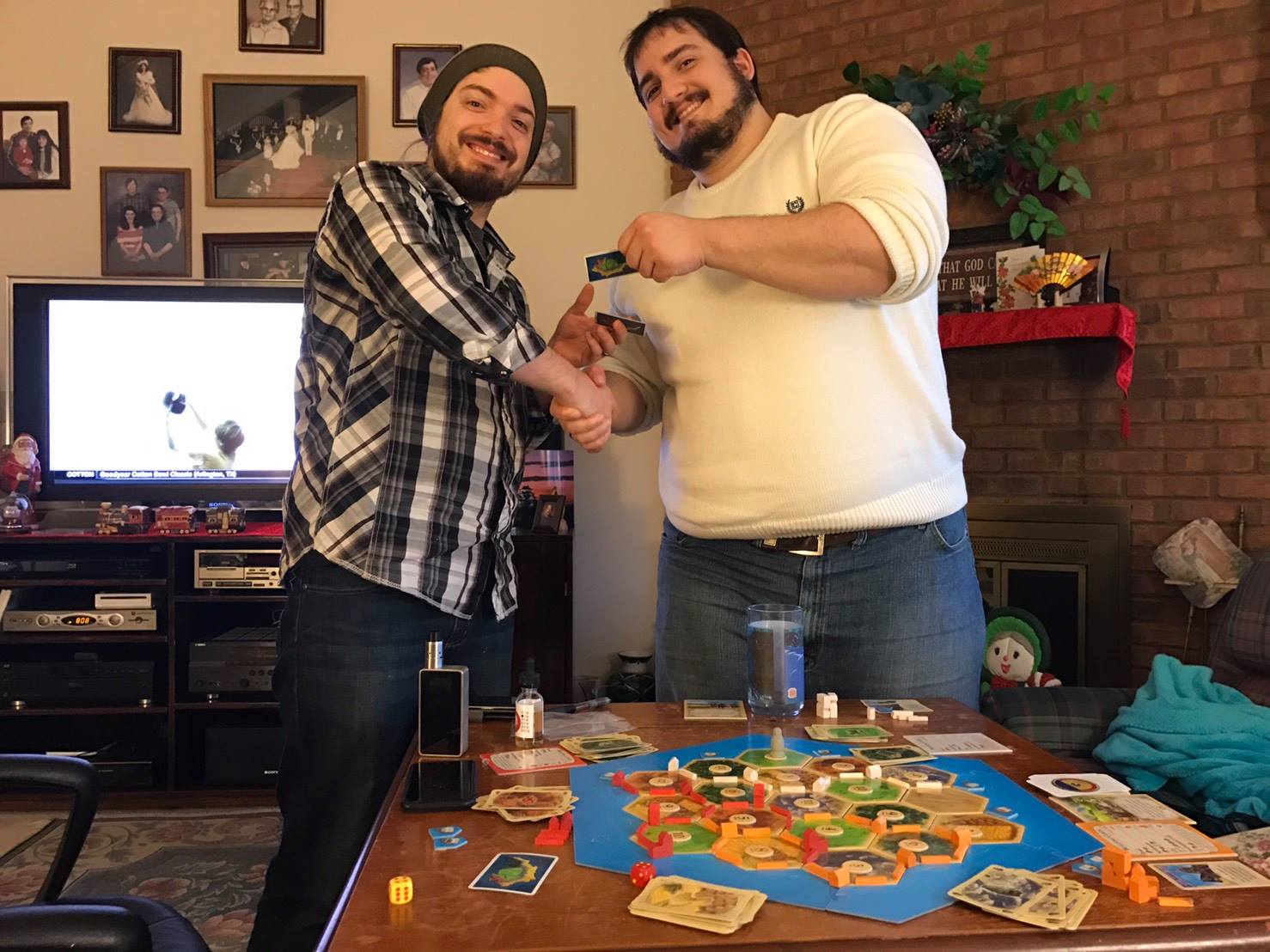Ethan shaking hands with the victorious Josh, right after they VICIOUSLY betrayed me in Catan by refusing to trade with me! It was Manifest Destiny, I tell you! You would have prospered under my rule! 